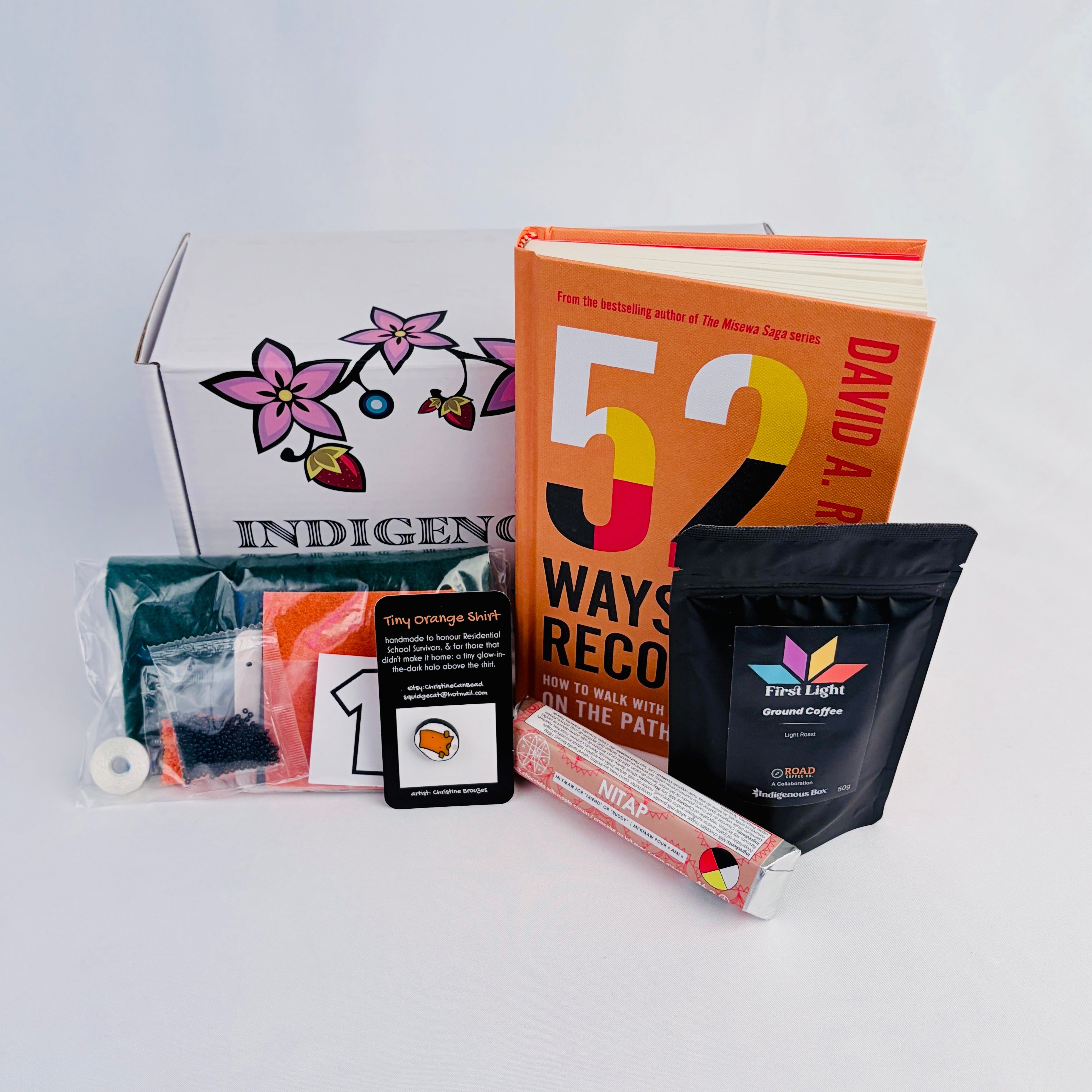 Collection of items including a book, coffee package, and other products on a light gray background