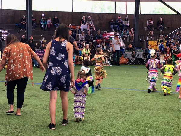 Sisters hold hands at the Saddle Lake pow wow