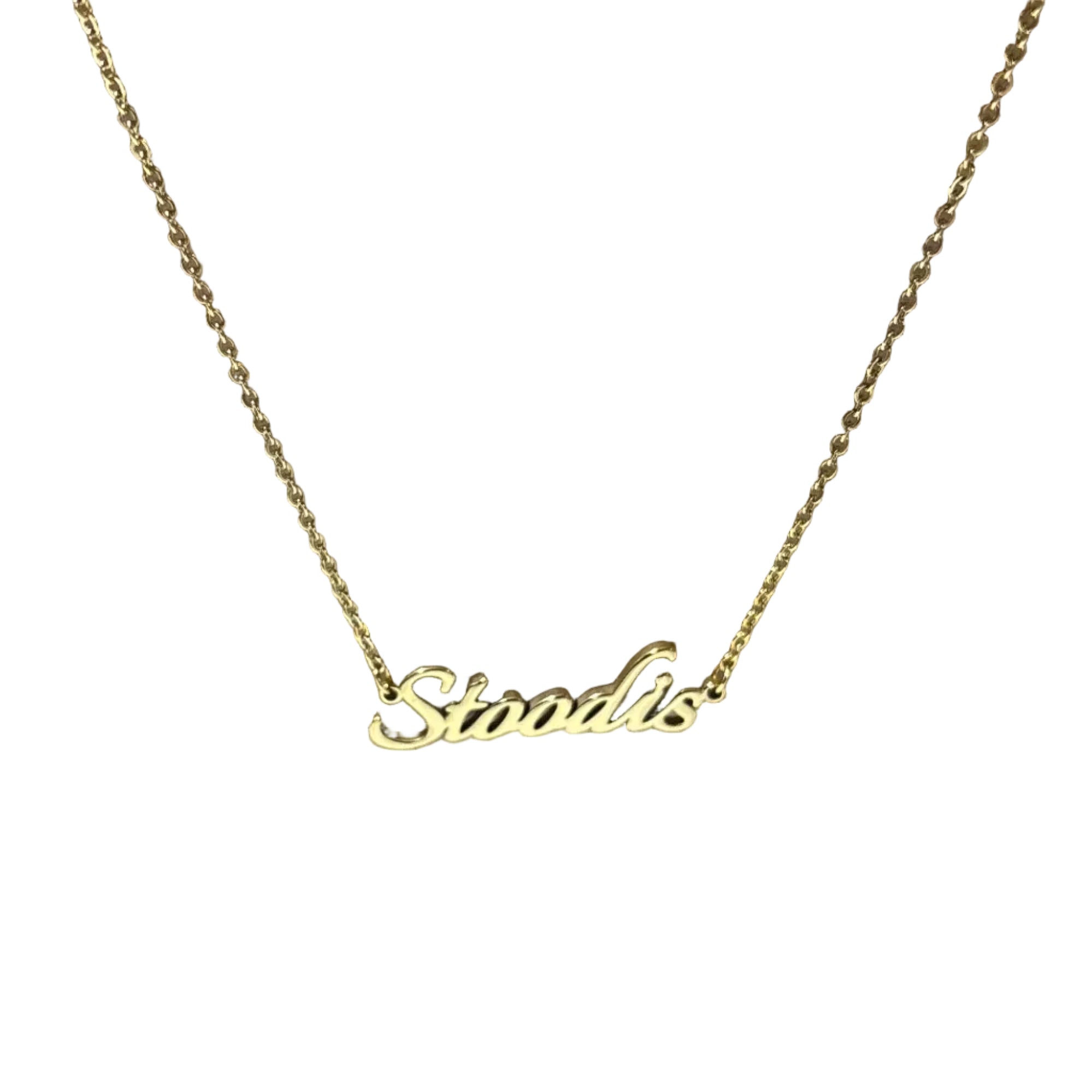 Gold necklace with 'Stoodis' pendant on a cardboard surface