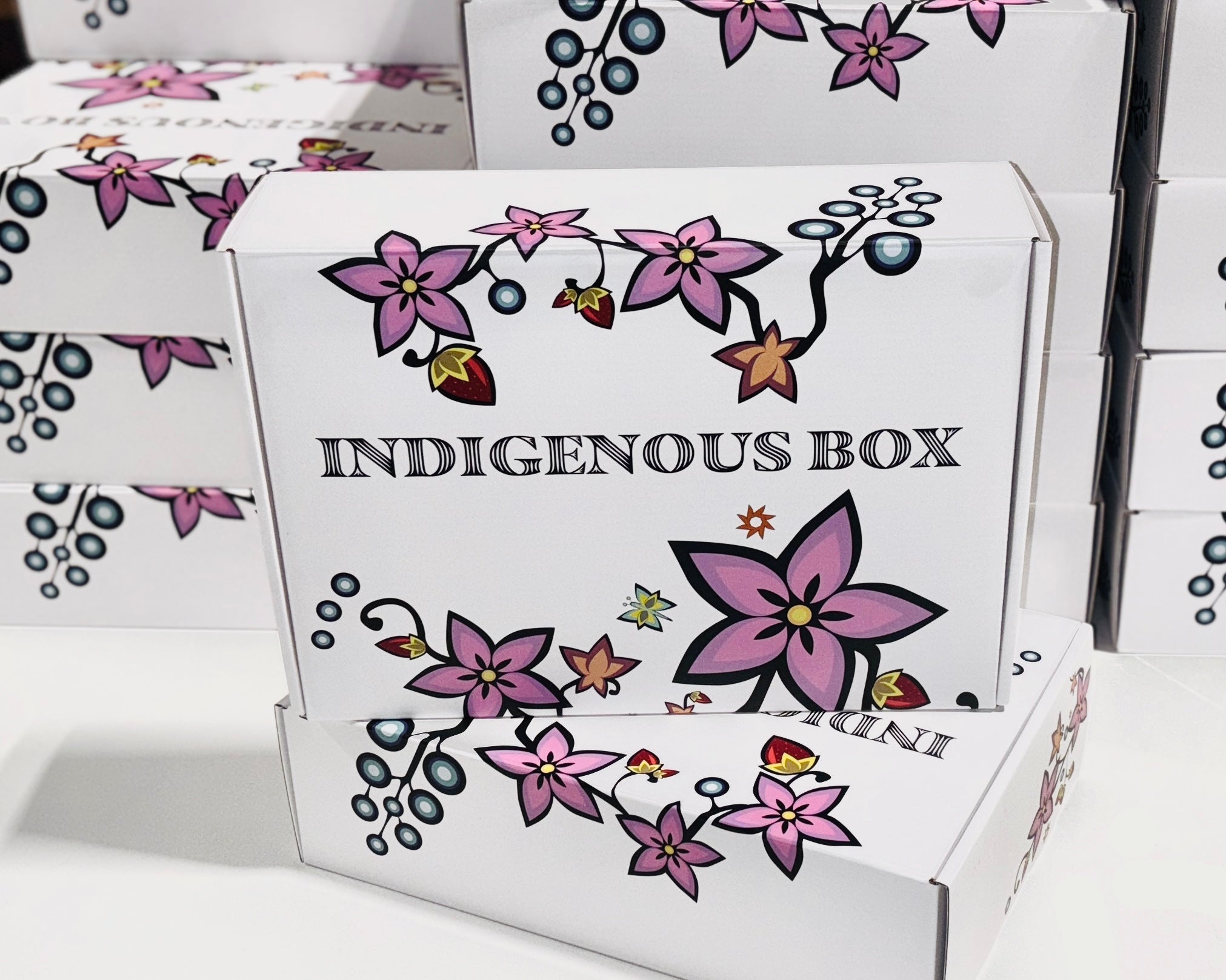 White boxes with floral designs and 'Indigenous Box' text on a white background